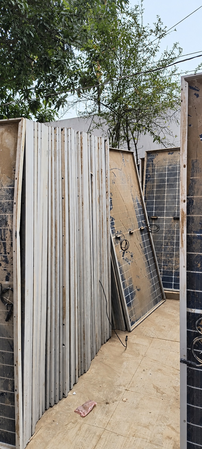 Rows of upright solar modules with visible dirt and backsheet damage
