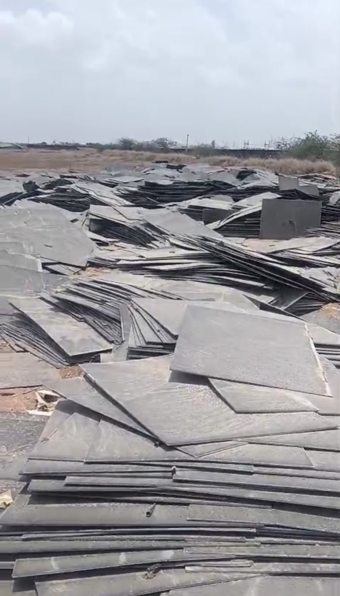 Loose piles of panel sections with visible damage outdoors
